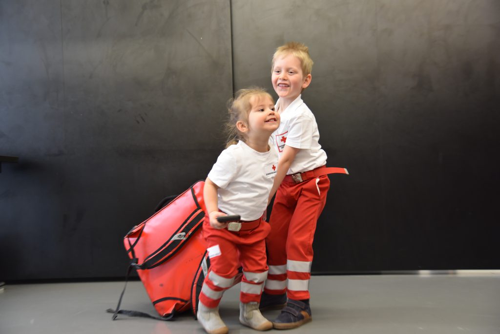 Bub und Mädchen in RK Uniform mit Notfallrucksack